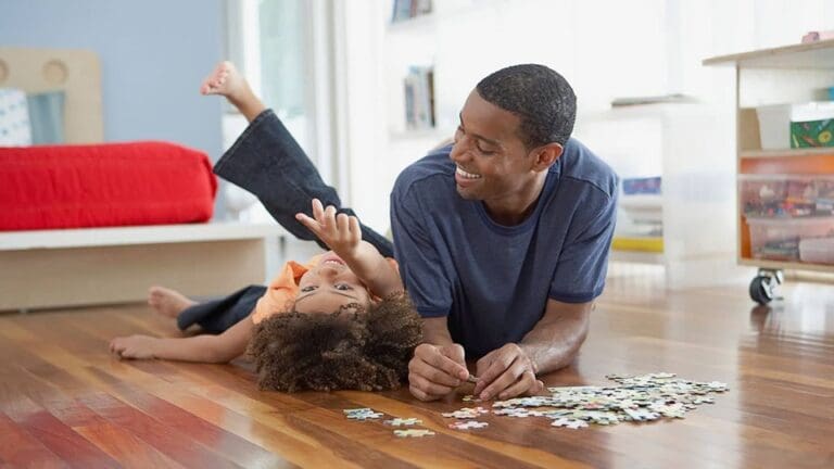 A father and child play on their home's beautiful hardwood floor