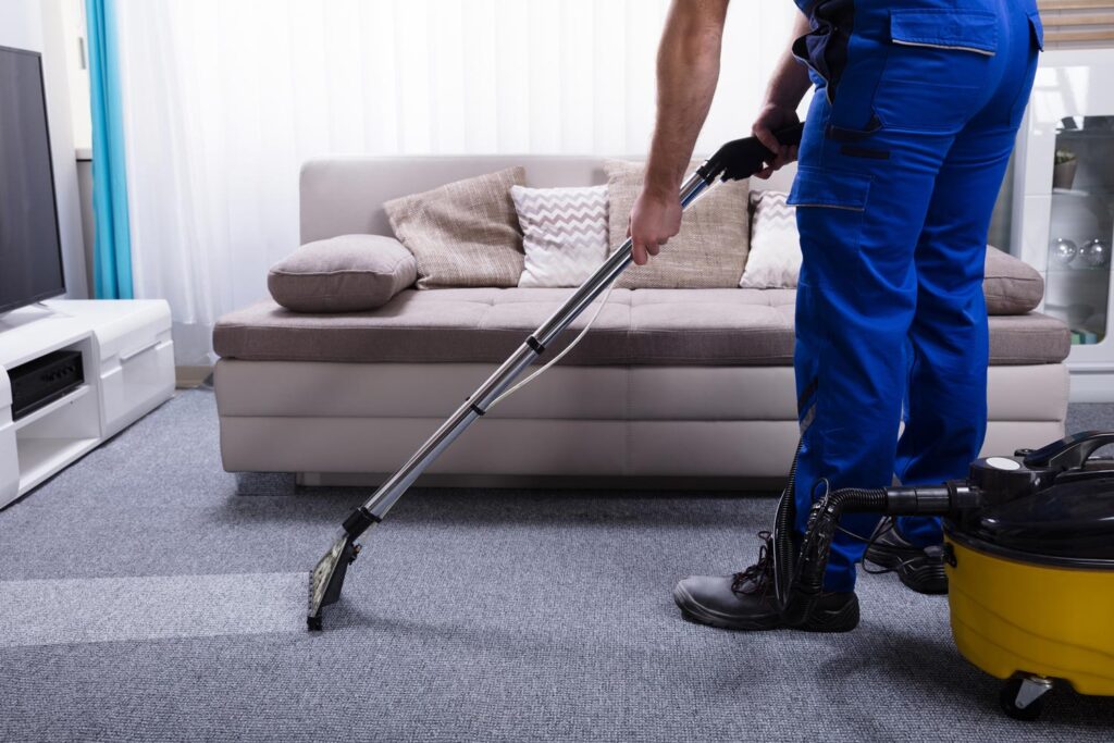 close shot of a person cleaning carpet with vacuum cleaner.