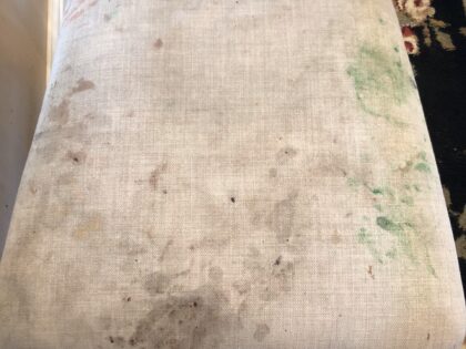 A dining room chair, badly stained with ground-in food